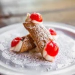 Mini Cannolis: Served with Sicilian ricotta with chocolate chips and topped with a maraschino cherry.